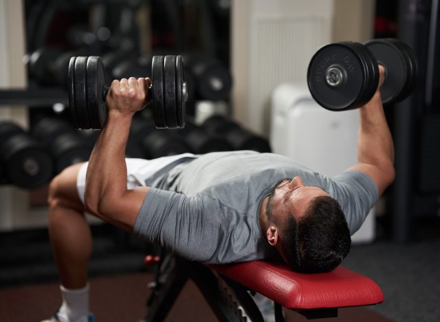 man doing dumbbell bench press exercises for men to build muscle