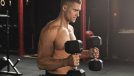 fitness man at gym doing bicep hammer curls with dumbbells to get bigger arms