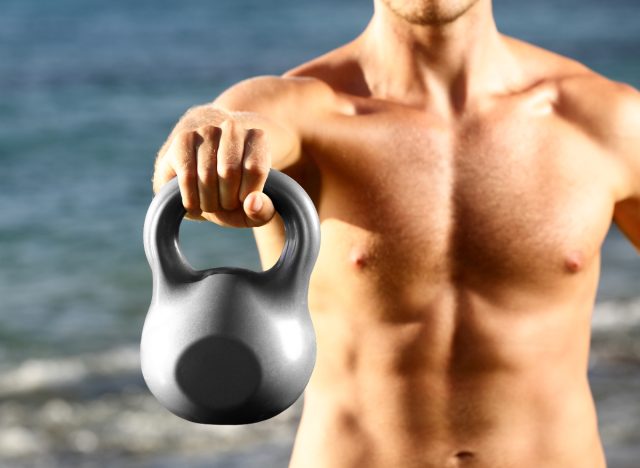 fitness man holding kettlebell, demonstrating kettlebell exercises to get rid of moobs