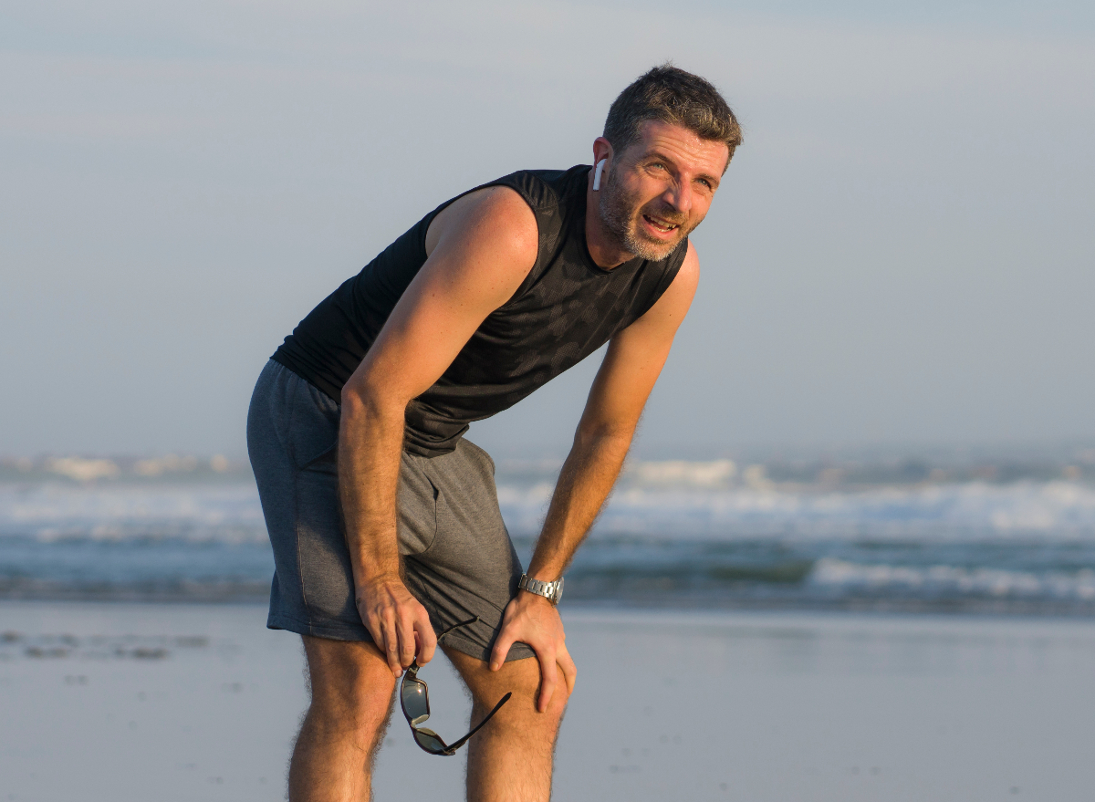 fitness man tired beach workout sprint, demonstrates exercise habits wrecking your body after 40