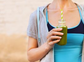 fitness woman holding green smoothie, concept of you'll never lose weight if you drink your calories