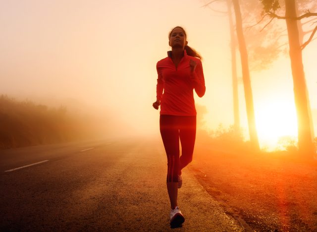 fitness woman running early in the morning outdoors while sun rises to lose weight before breakfast
