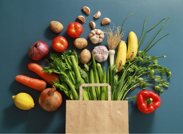 healthy fruits and veggies bursting out of shopping bag, healthy eating concept