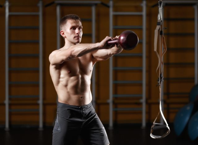 fit man doing kettlebell swings