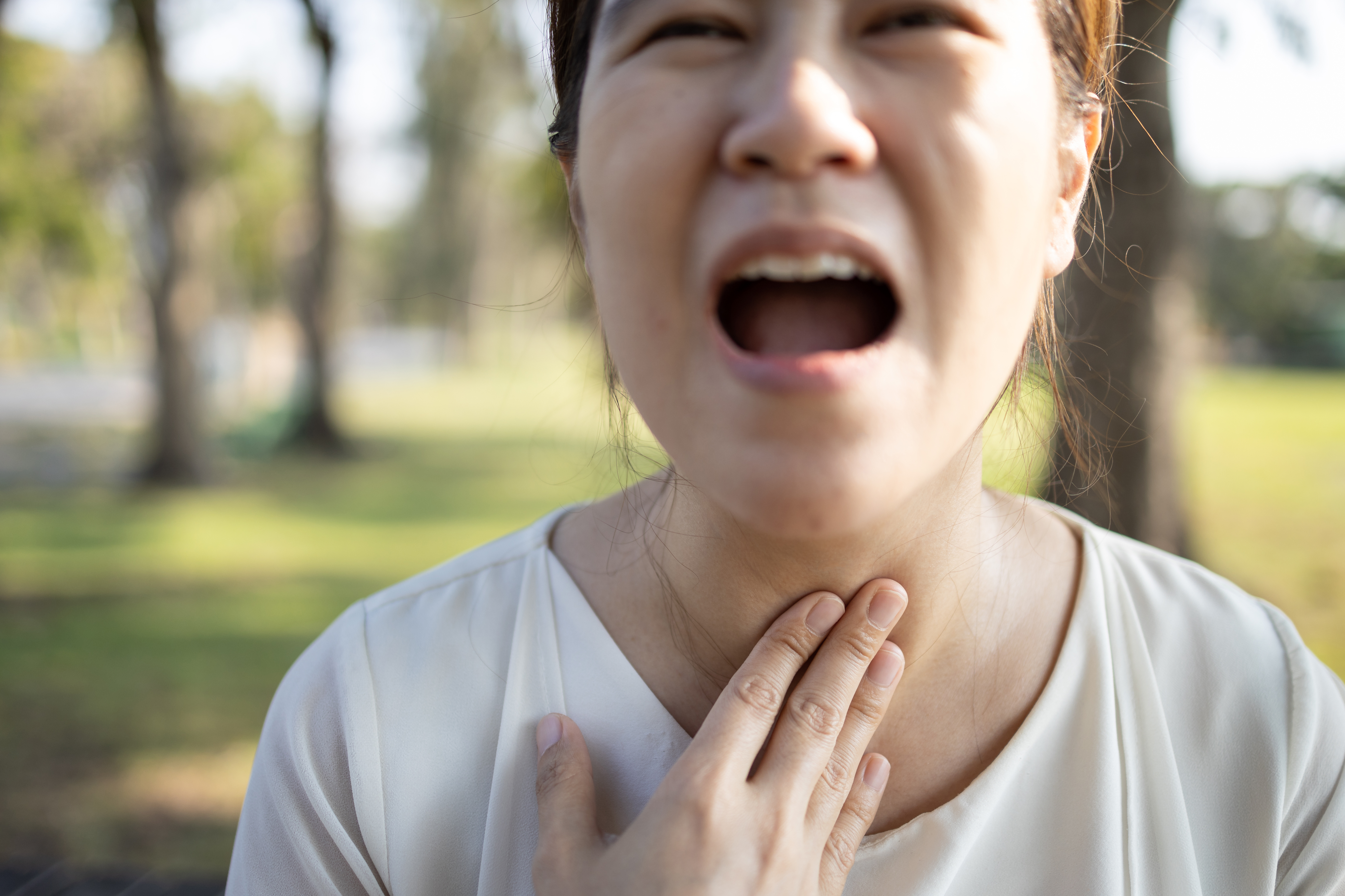 Close,Up,Of,Hands,Touching,Neck,sick,Asian,Girl,Has,Strong