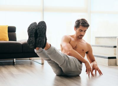 fit man at home doing ab twists in bright living room, demonstrating how to fight winter weight gain