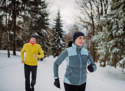 mature couple on snowy path engaging in winter walking workout to lose five pounds