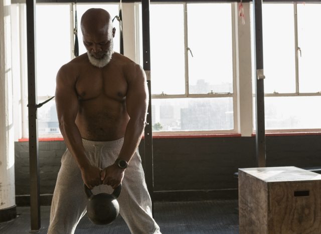 mature senior man doing kettlebell deadlifts