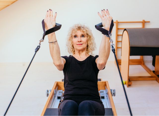 mature senior woman on Pilates reformer