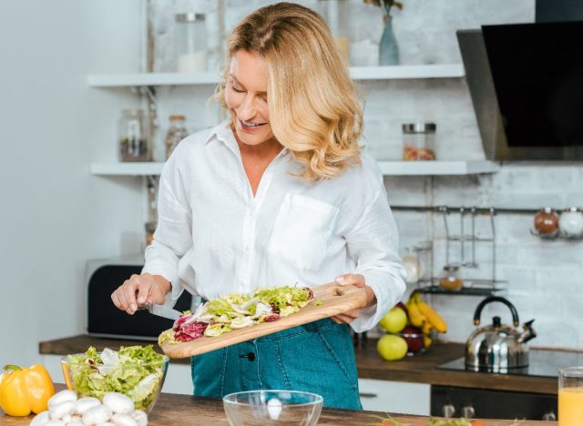 mature woman healthy cooking in bright kitchen, concept of best weight loss diets of 2023