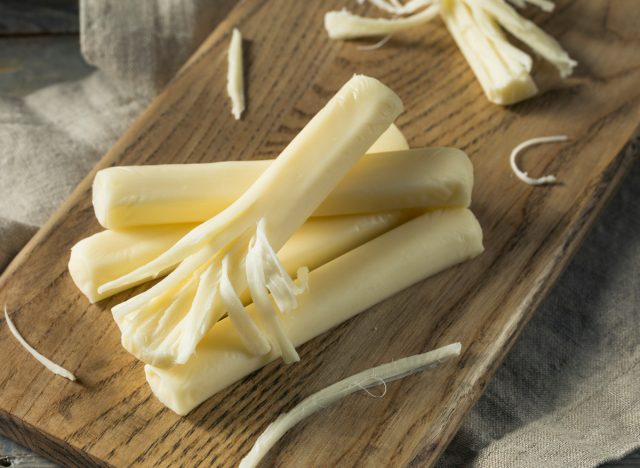 Cheese strands on a cutting board, healthy foods to lose weight faster