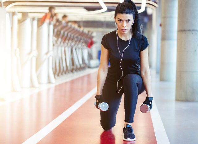 woman doing dumbbell lunges at the gym, exercises to lose face fat