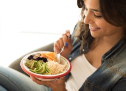 woman eating healthy vegan bowl, close-up, concept of eating less for weight loss