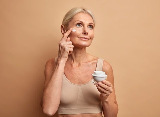 woman addressing crepey skin with skincare products, eye cream