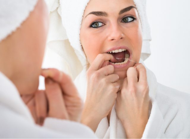 woman flossing her teeth