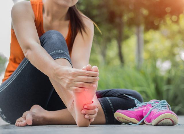 woman experiencing foot strain from running, dangers of running for exercise