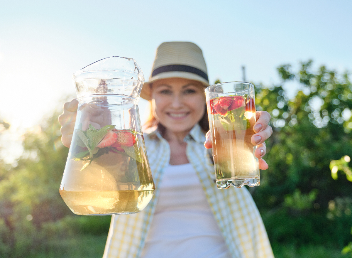 woman holding pitcher and glass of berry iced tea, concept of diet-related weight loss tips for women