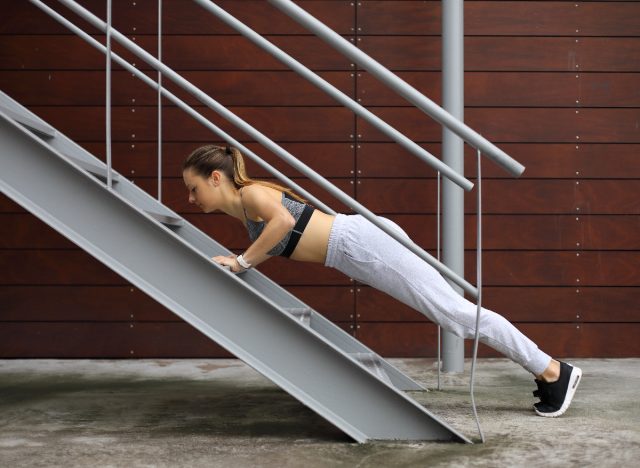 woman doing incline pushups on stairs