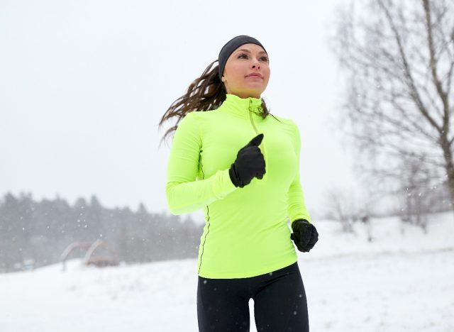 雪の降る冬の女性が休暇中に体重を減らすために運動する