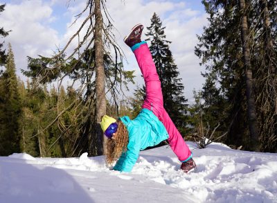 woman stretching on ski mountain with snow