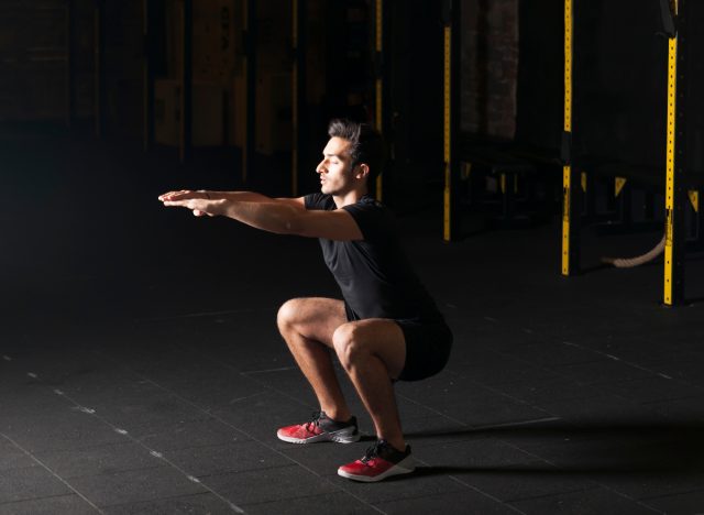 muscular man doing air squats