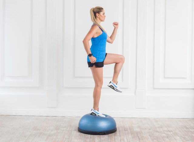 fitness woman demonstrating balancing exercise on BOSU ball