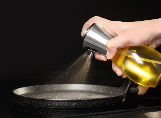 cooking oil in spray bottle going onto pan