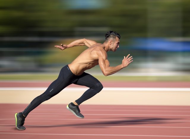 fitness man sprinting on track, demonstrating boot camp workout to flatten your belly in 30 days