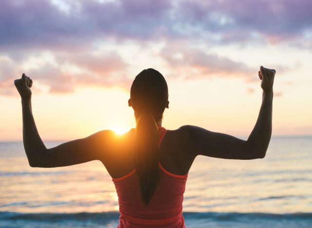 strong fitness woman sunset beach