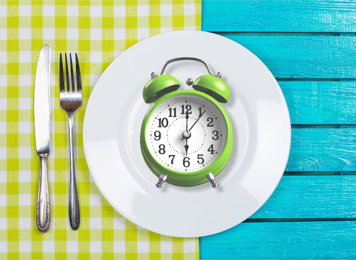 intermittent fasting concept, alarm clock on dinner plate