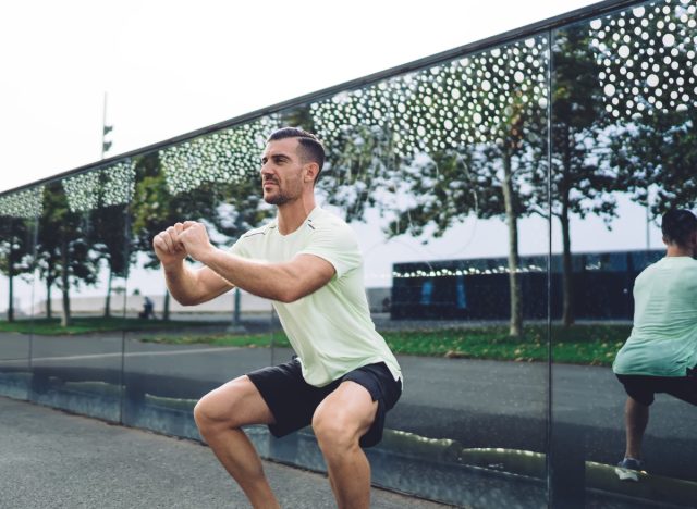 muscular man doing bodyweight squats, exercises for men to build muscle