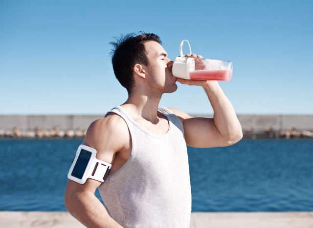 fitness man drinking protein shake outdoors, concept of eating mistakes for building muscle, over-doing it on protein