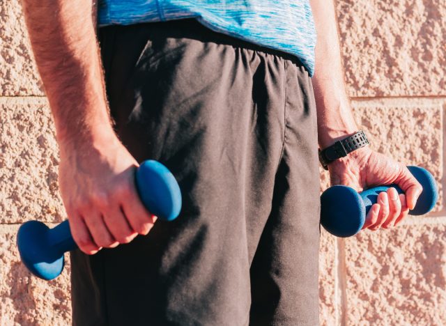 man holding light weights