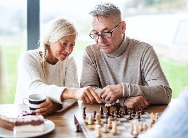 Mature couple figuring out their chess move against opponent