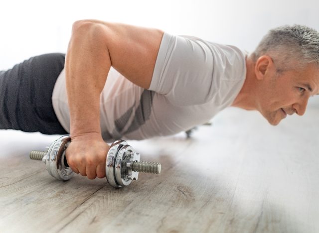 mature man performing dumbbell pushups, concept of exercises to do to lose your large belly