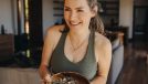 mature woman holding bowl of salad at home, easy ways to lose weight when you're just starting out