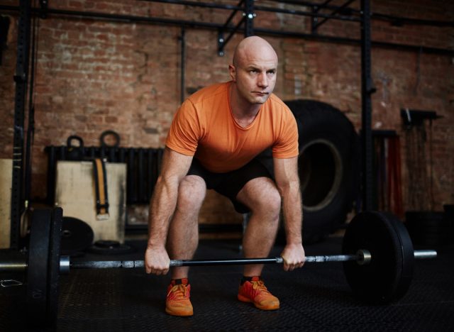 middle-aged man lifting heavy barbell to get strong after 40
