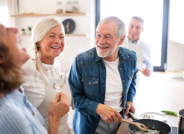 happy older couples in bright kitchen, cooking, having dinner party concept of how to feel younger than your age