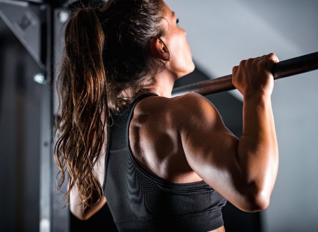 strong fitness woman doing pull-ups strength-building exercises