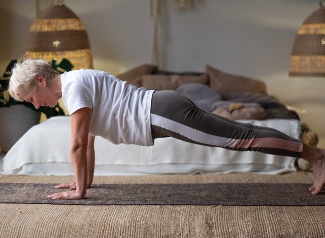 mature senior woman doing plank in bedroom, part of workout to lose 10 pounds fast