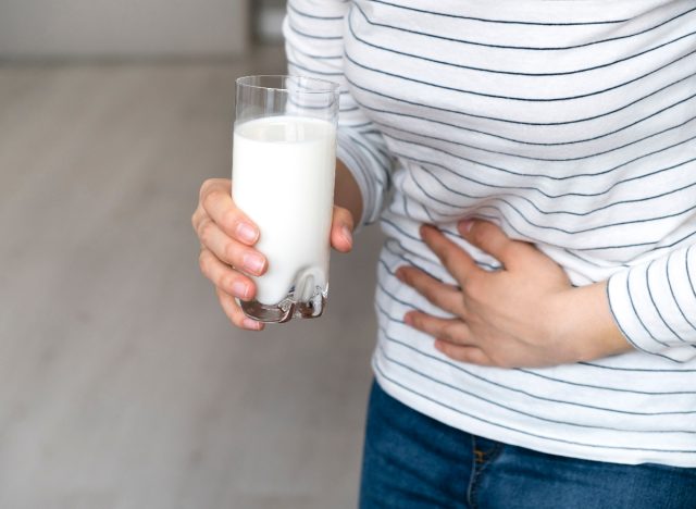 woman holding milk feeling bloated