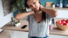 woman doing neck stretches for a stiff neck in her kitchen
