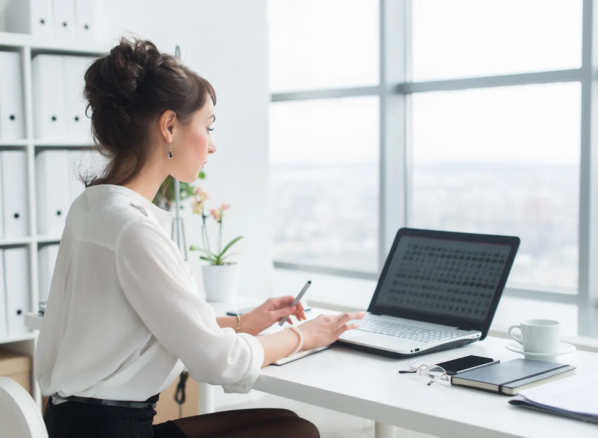 woman sitting at desk, concept of sedentary life leading to flat butt