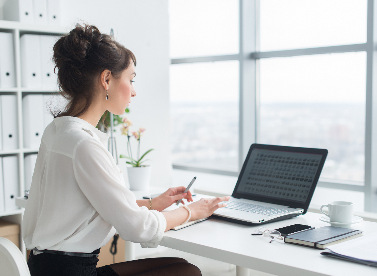 https://www.eatthis.com/wp-content/uploads/sites/4/2023/02/woman-sitting-desk.jpg?quality=82&strip=1