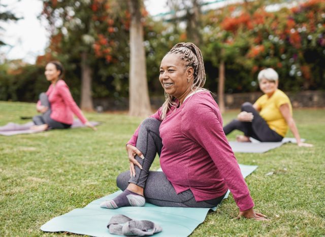 mature woman doing yoga mobility work outdoors