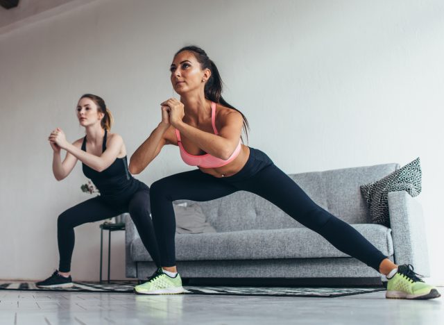 two women doing side lunges in family room, part of couch potato workout