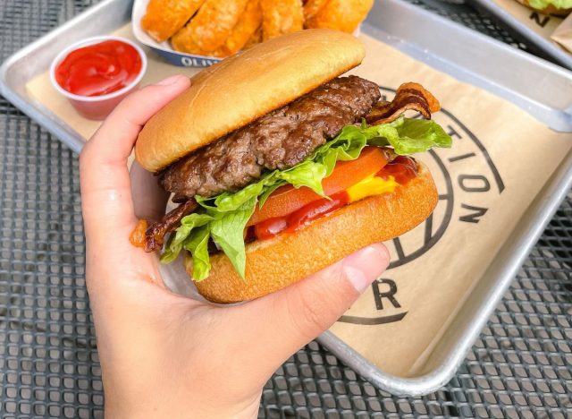 hand holding a hamburger from Elevation Burger