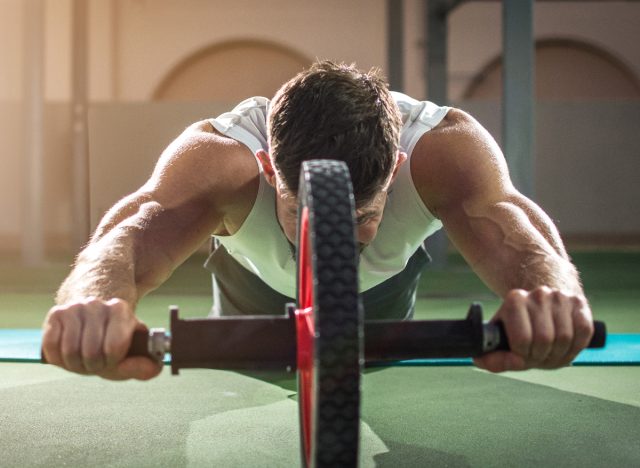 man doing ab wheel rollout core-strengthening exercises for men