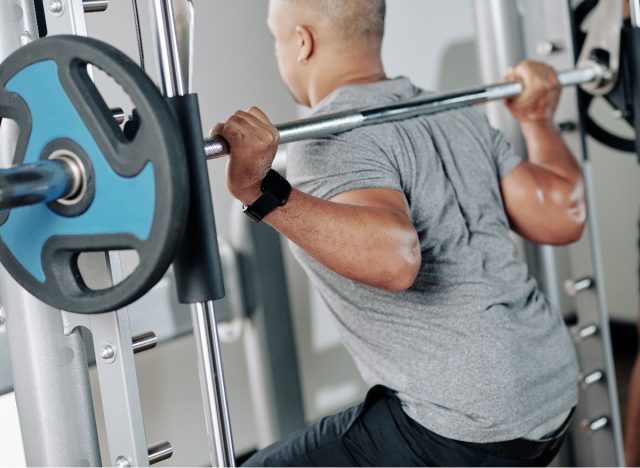 man doing barbell back squats