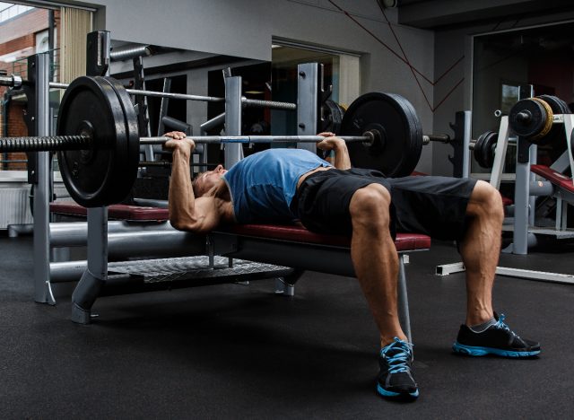 man doing barbell bench press exercise